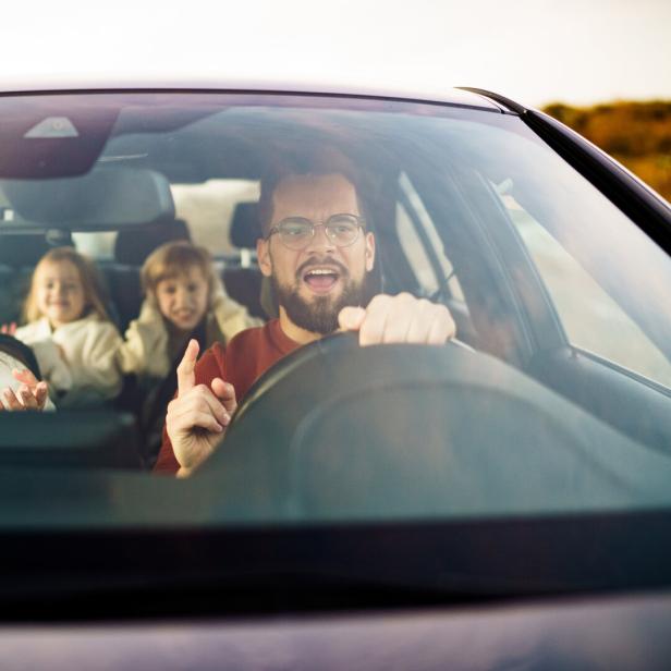 Mother and father are arguing while the children are sitting in the car