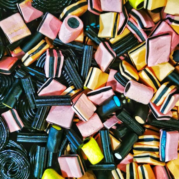 Eine bunte Mischung aus Lakritzschnecken und Lakritzkonfekt in verschiedenen Formen und Farben liegt durcheinander.