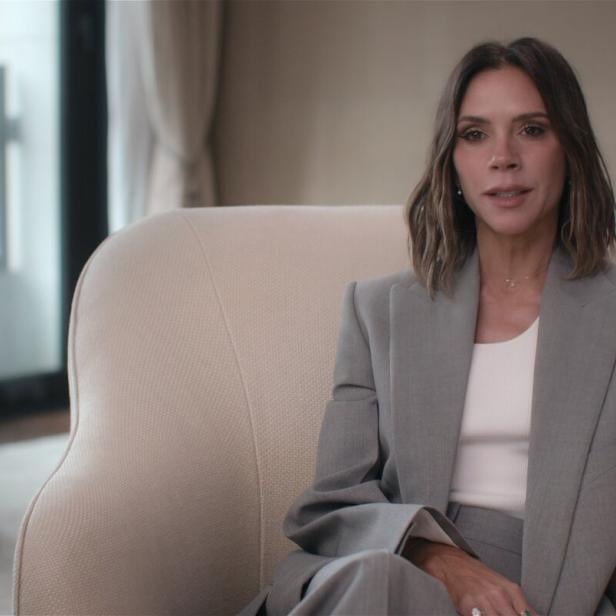 In der Netflix-Serie zeigt sich Victoria Beckham im grauen Blazer und weißem Shirt. 