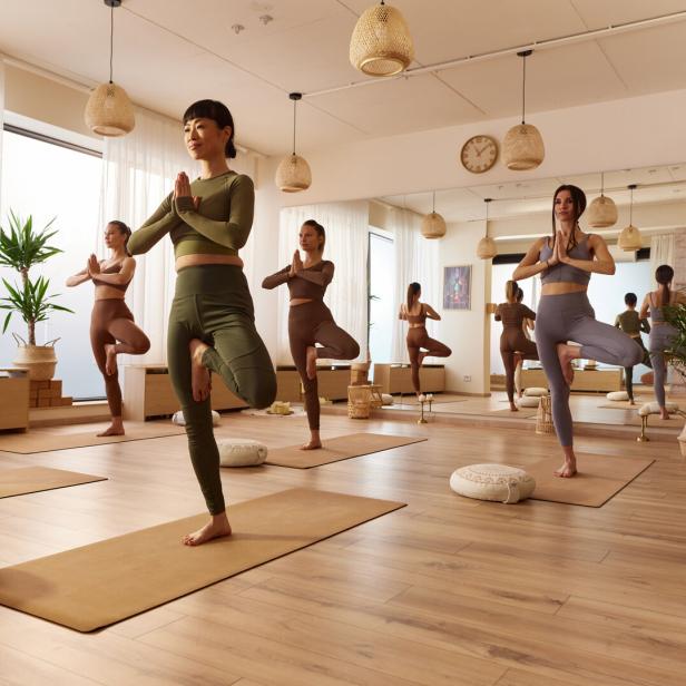 Frauen, die in einem Studio Yoga betreiben