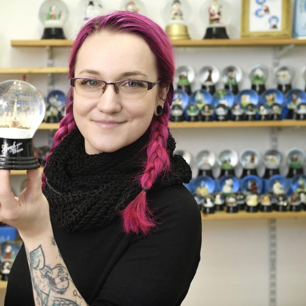 Junge Frau mit Schneekugel und roten Haaren