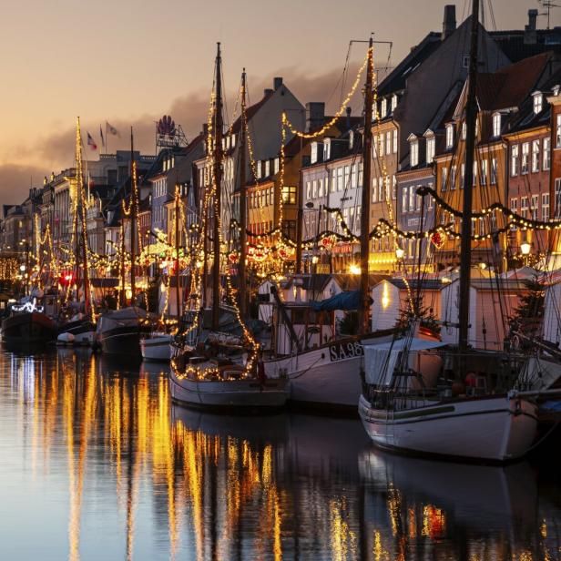 Den Nyhavn von Kopenhagen bei Nacht mit vielen Lichtern 