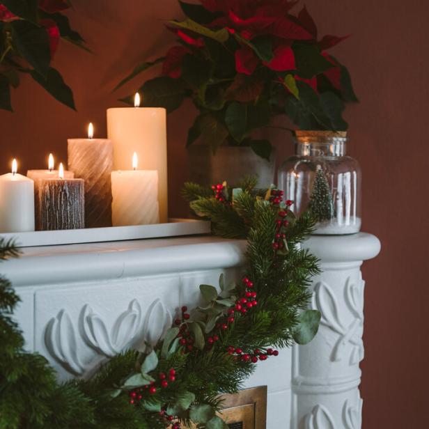 Ein mit Kerzen geschmückter, weinachtlicher Kamin.