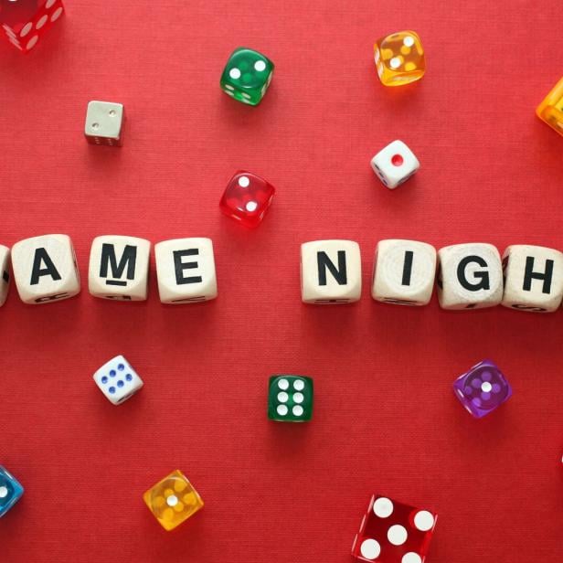 Wooden word dice spell 'Game Night' with multicoloured dice around it.