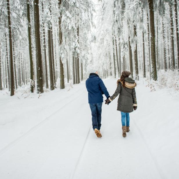 Paar spaziert im verschneiten Wald