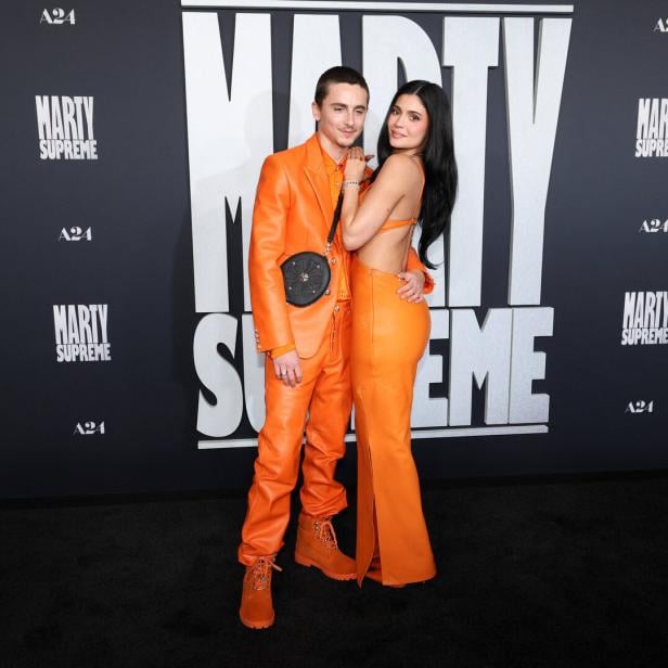 Timothée Chalamet und Kylie Jenner posieren gemeinsam in oranger Kleidung.