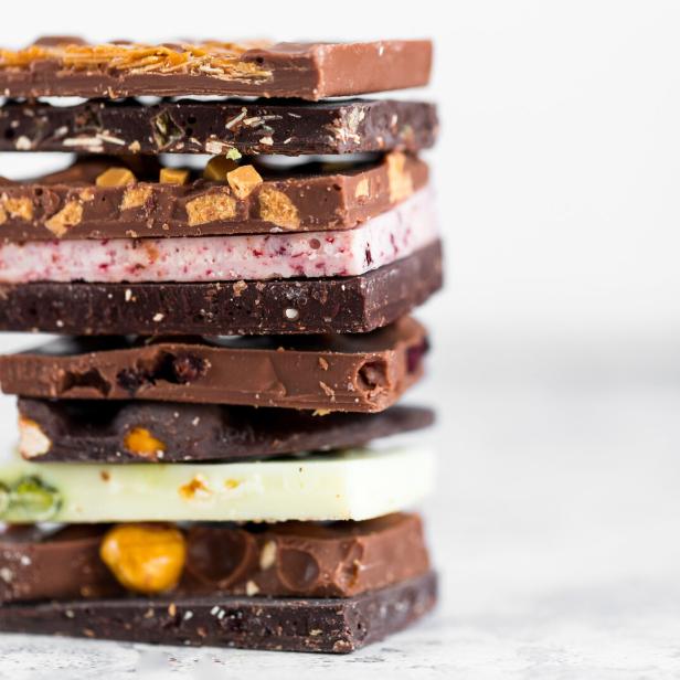 Mehrere unterschiedlich gefüllte und geschichtete Schokoladentafeln sind übereinander gestapelt.