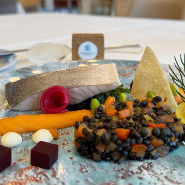 In Butter konfierter Seesaibling auf Linsensalat mit Saiblingskaviar, kunstvoll angerichtet auf einem Teller