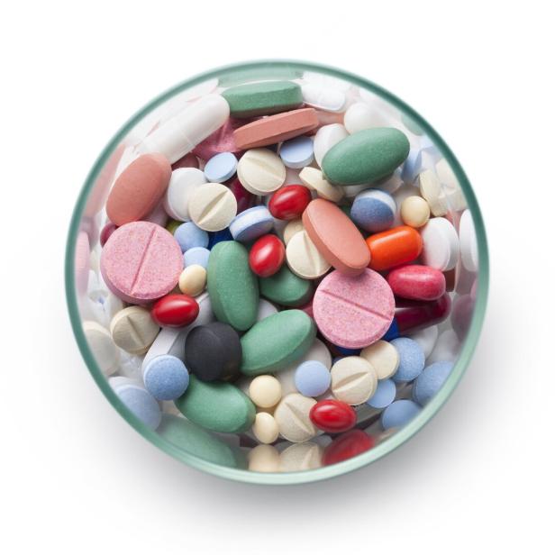 Ein Glas ist gefüllt mit einer Vielzahl von bunten Pillen und Tabletten.