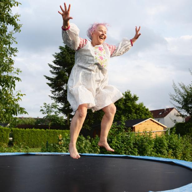 Senior woman with overweight jumping on trampoline