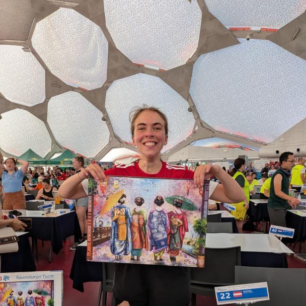 Simone Reicht, Team-Staatsmeisterin im Speed Puzzeln, hält stolz ihr fertig gestelltes Puzzle im Einzelbewerb der Weltmeisterschaft hoch