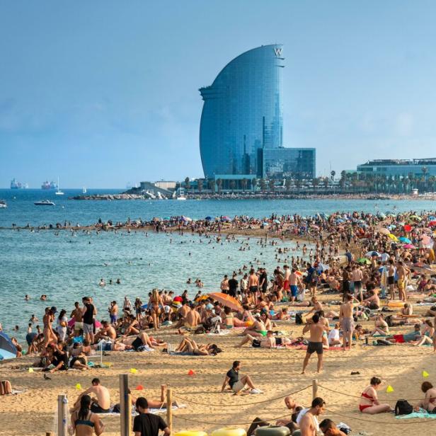 Ein Strand in Barcelona mit einem bekannten Hotel im Hintergrund