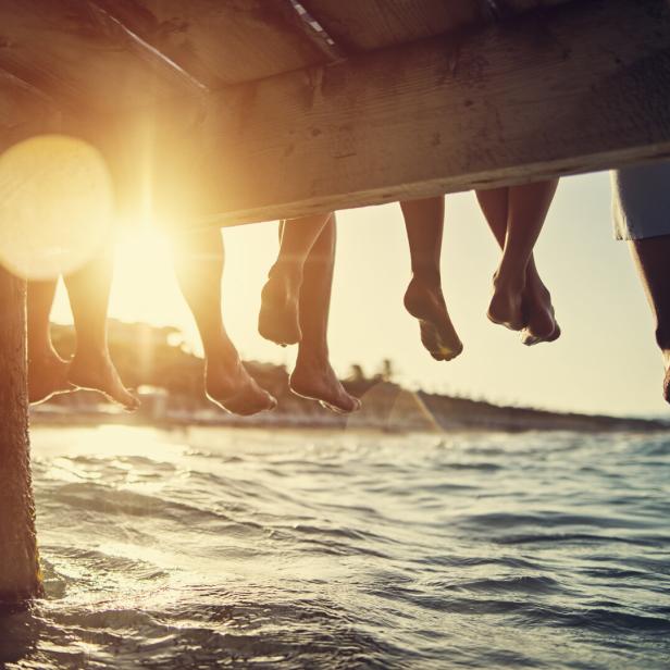 Family sitting on pier by the sea