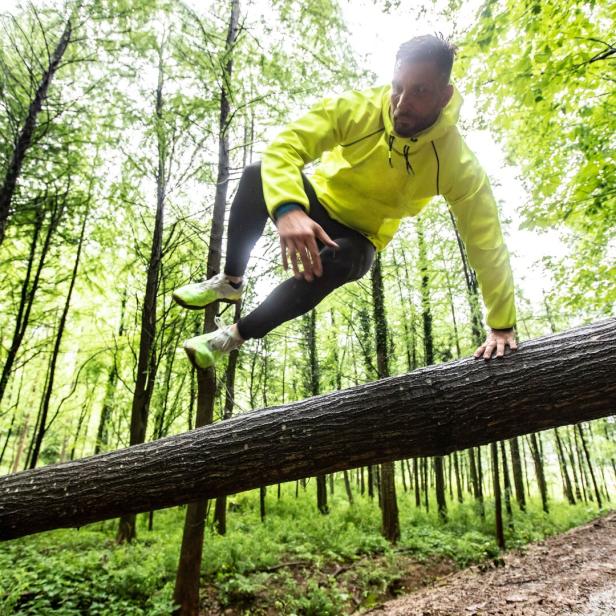 Adult Man Running in Forest in Bad Weather